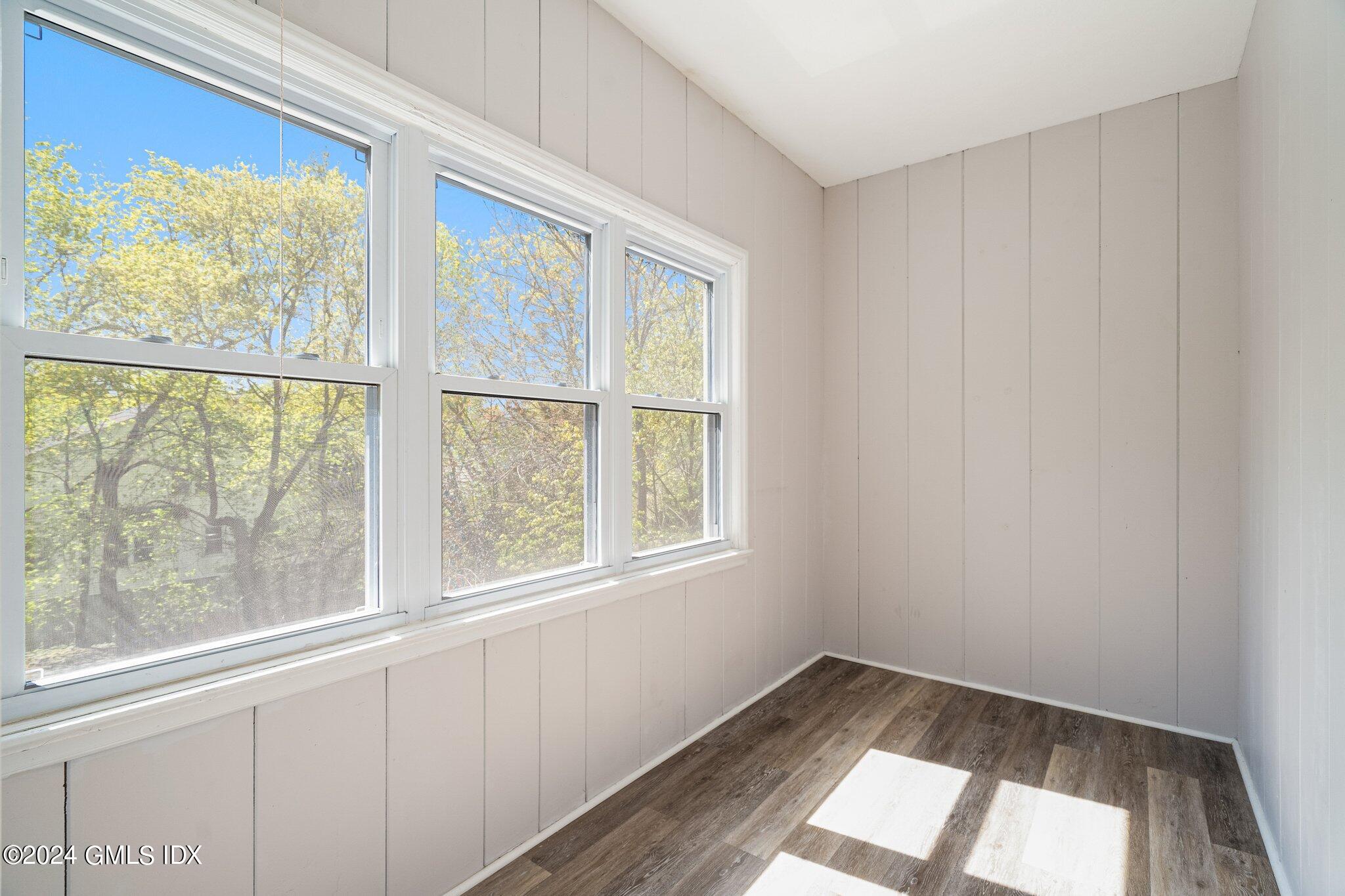 14 Byram Shore Road, Unit 1 Greenwich, CT 06830 - Photo 14 of 19 a view of an empty room with wooden floor and a window