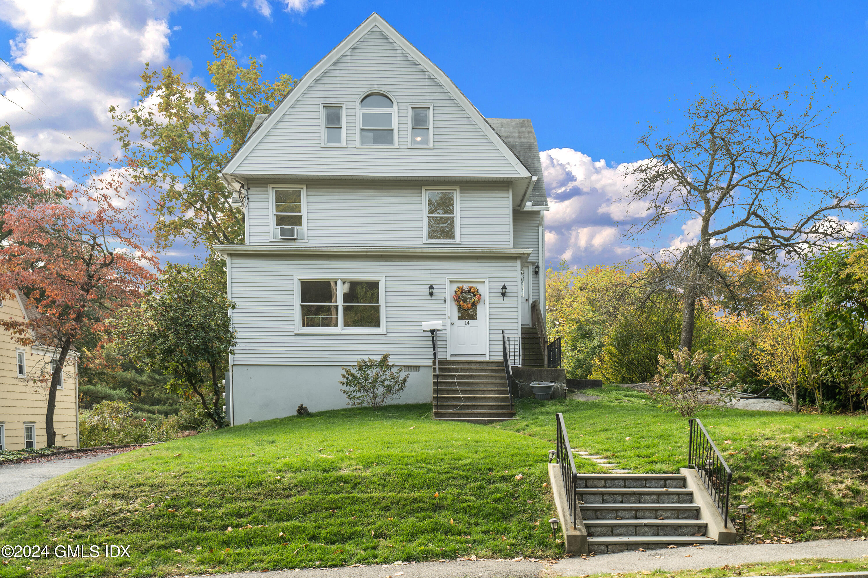14 Byram Shore Road, Unit 1 Greenwich, CT 06830 - Photo 2 of 19 a front view of a house with a yard