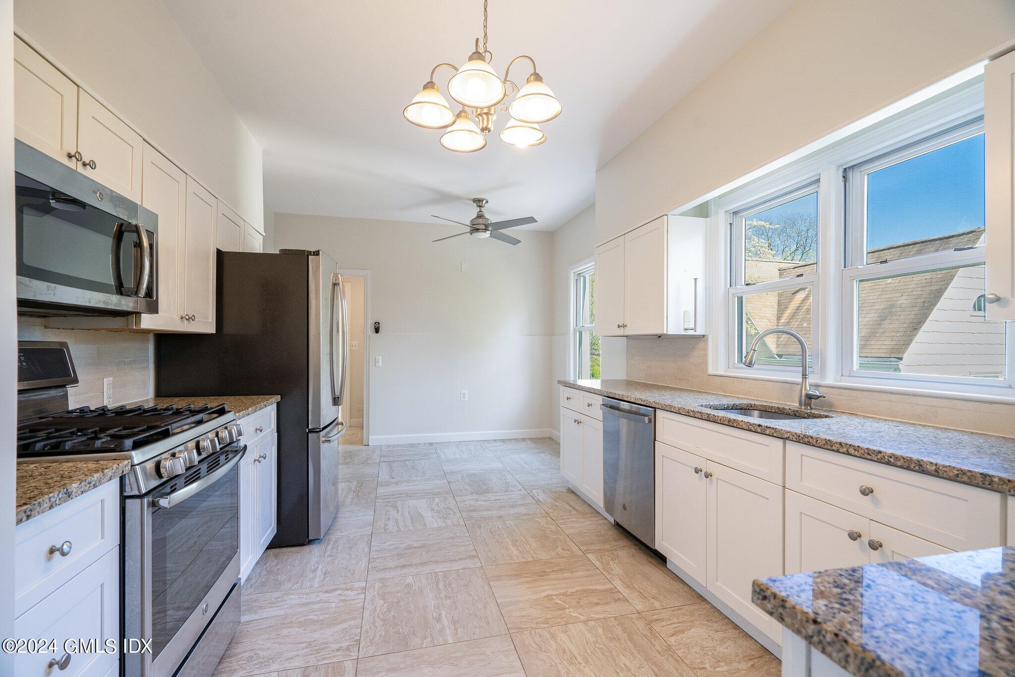 14 Byram Shore Road, Unit 1 Greenwich, CT 06830 - Photo 7 of 19 a kitchen with stainless steel appliances granite countertop a stove a sink and a refrigerator