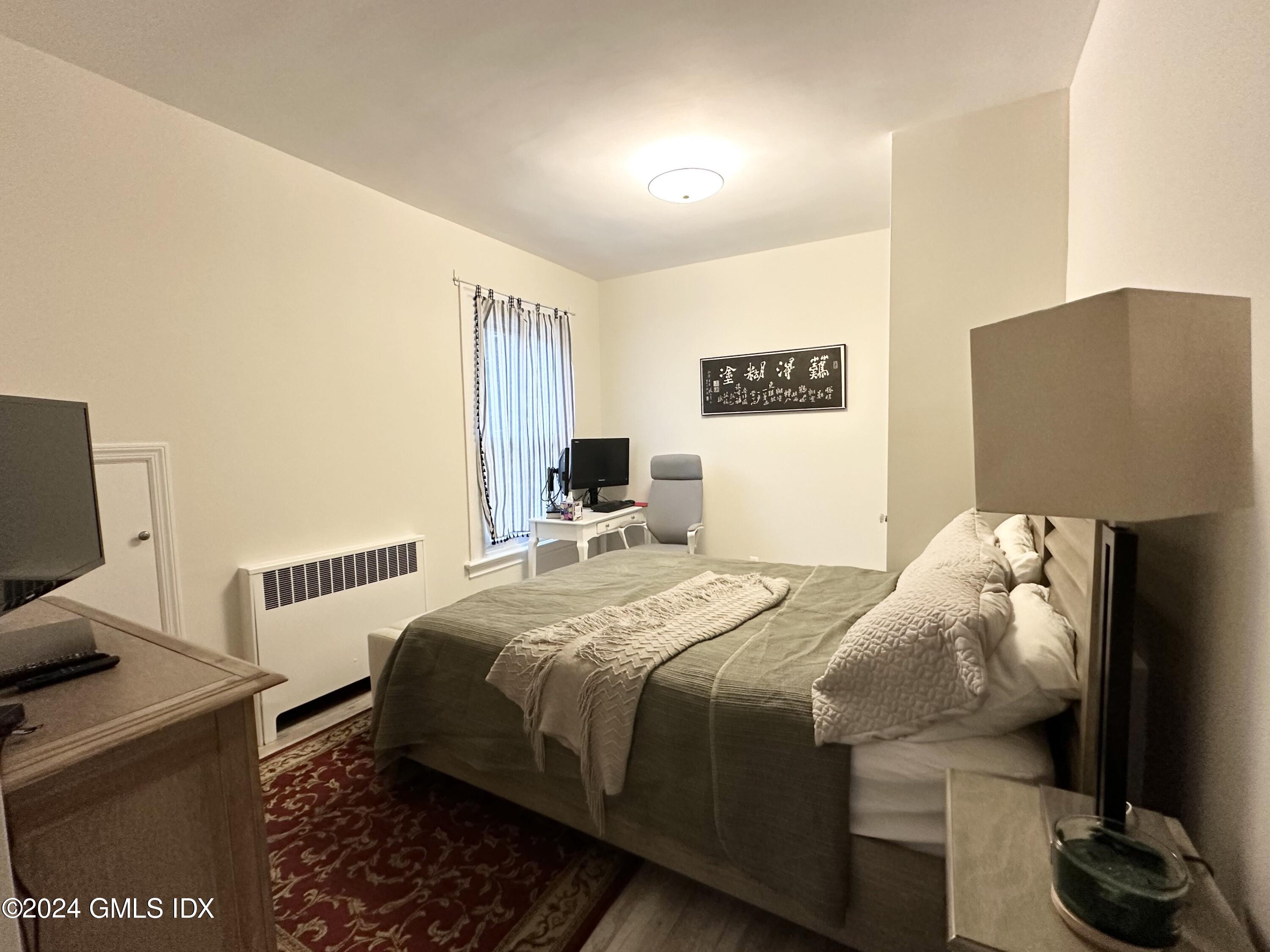 14 Byram Shore Road, Unit 1 Greenwich, CT 06830 - Photo 10 of 19 a bedroom with a bed and a television