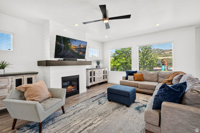 6536 West Muirfield Road Highland, UT 84003 - Photo 3 of 48 Living area featuring a shiplap-accented fireplace with a dark wood-finish mantel, recessed lighting, and a ceiling fan