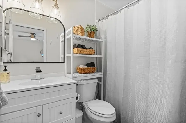 a bathroom with a sink a toilet and shower curtain