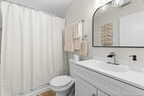 a bathroom with a sink a toilet and a mirror