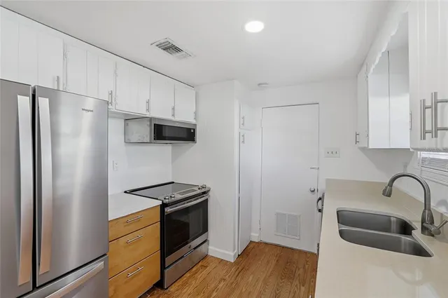 a kitchen with stainless steel appliances a refrigerator stove and sink