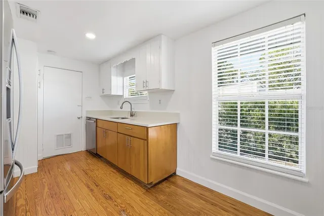 a kitchen with a sink cabinets appliances and a window