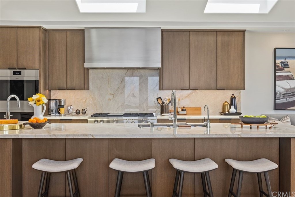 846 Emerald Bay Laguna Beach, CA 92651 - Photo 17 of 42 a kitchen with stainless steel appliances granite countertop a sink a stove and white cabinets