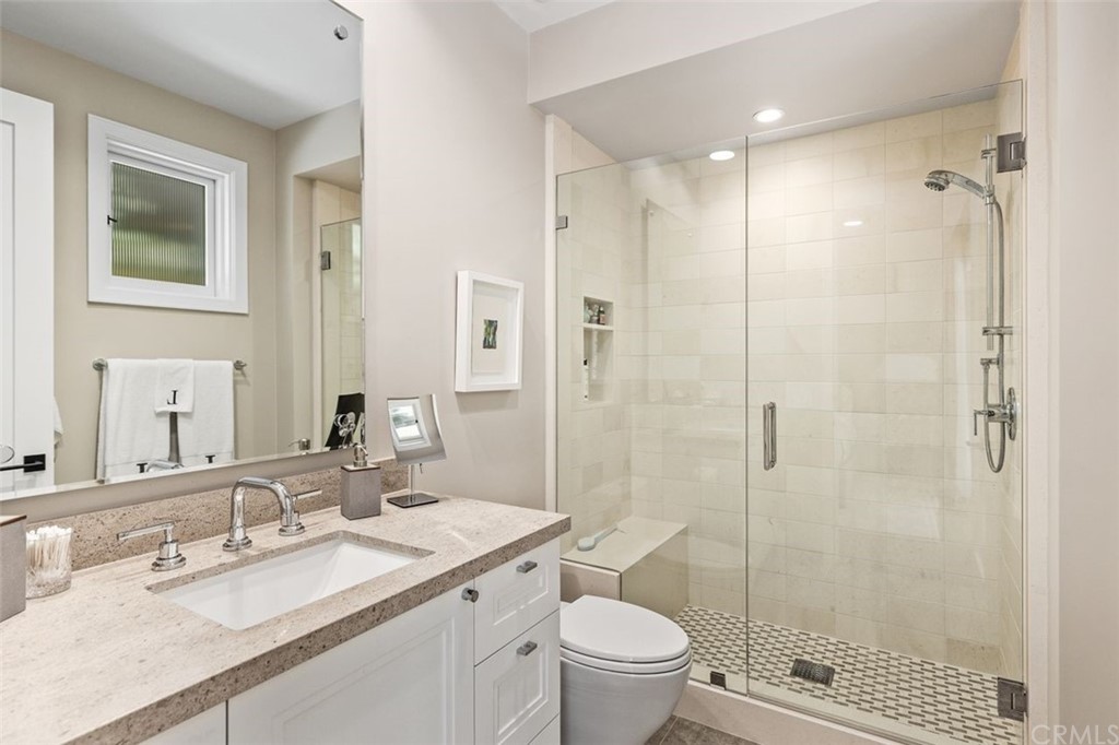 846 Emerald Bay Laguna Beach, CA 92651 - Photo 39 of 42 a bathroom with a granite countertop sink toilet mirror and shower