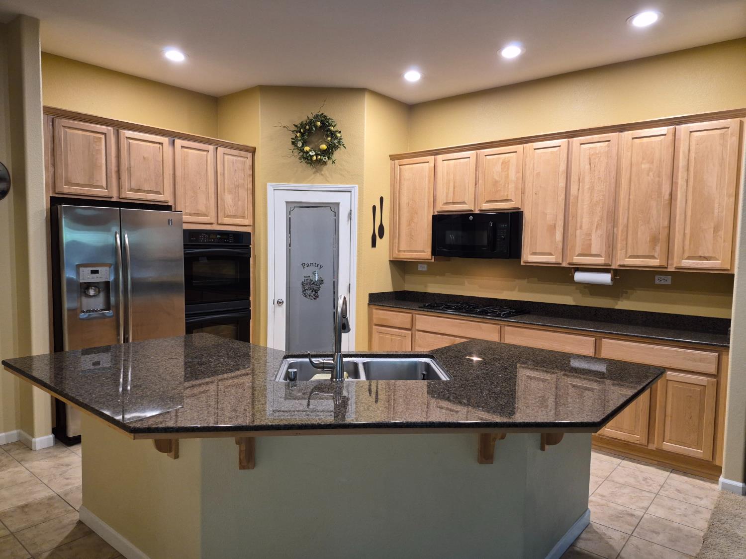 1845 Indiana Street Gridley, CA 95948 - Photo 4 of 12 a kitchen with kitchen island granite countertop a sink and refrigerator
