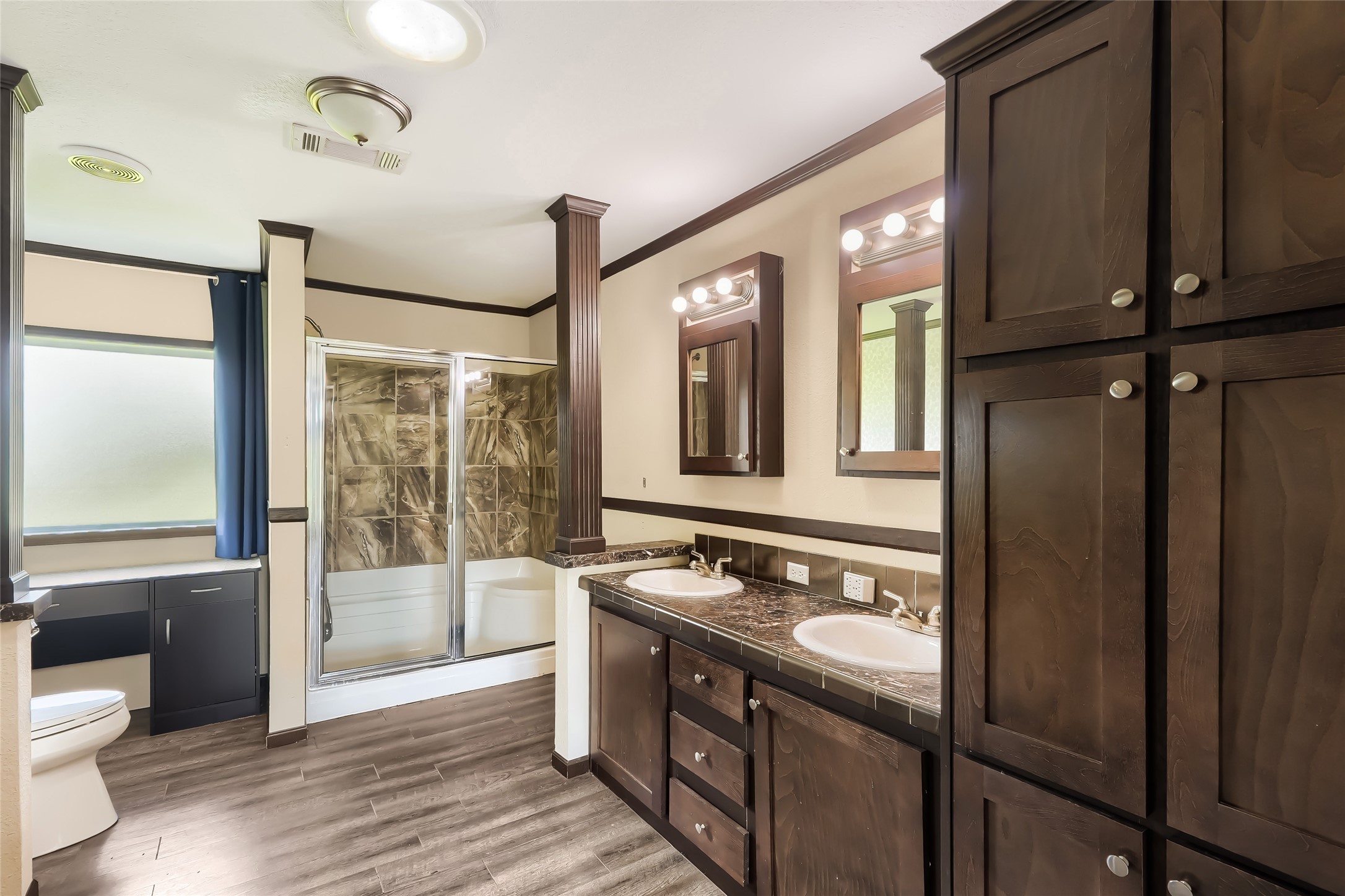 401 Graef Road Kyle, TX 78640 - Photo 16 of 30 Double vanity and tiled shower enhance a well-appointed bathroom space.
