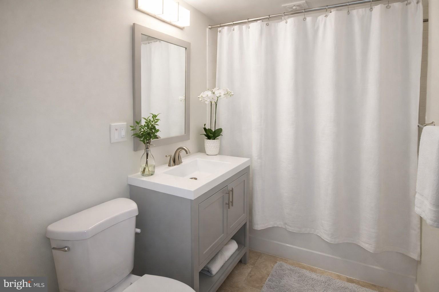 7548 Spring Lake Drive, Unit A Bethesda, MD 20817 - Photo 12 of 23 a bathroom with a sink a toilet and shower