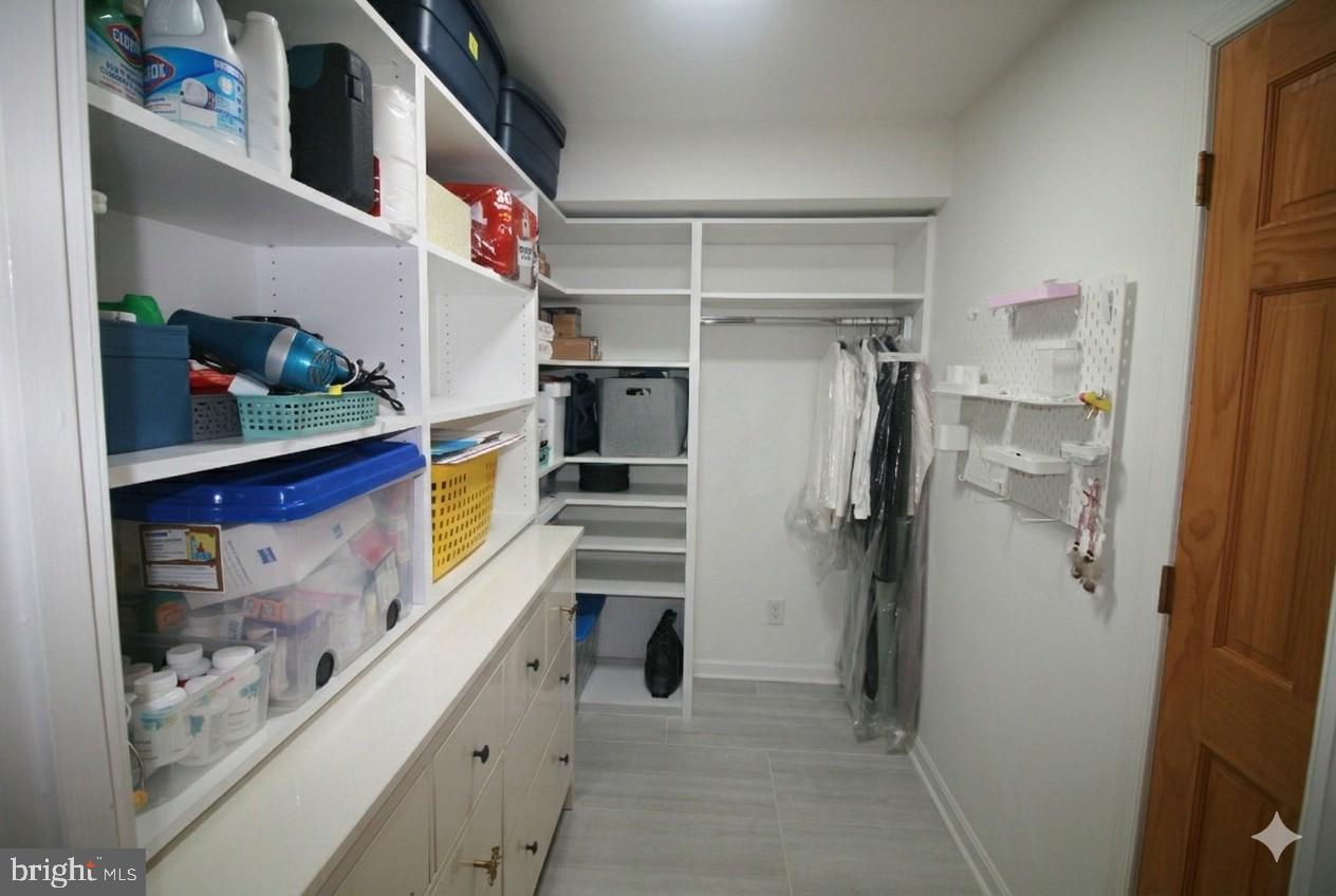 7548 Spring Lake Drive, Unit A Bethesda, MD 20817 - Photo 13 of 23 a view of walk in closet with clothes and shoes