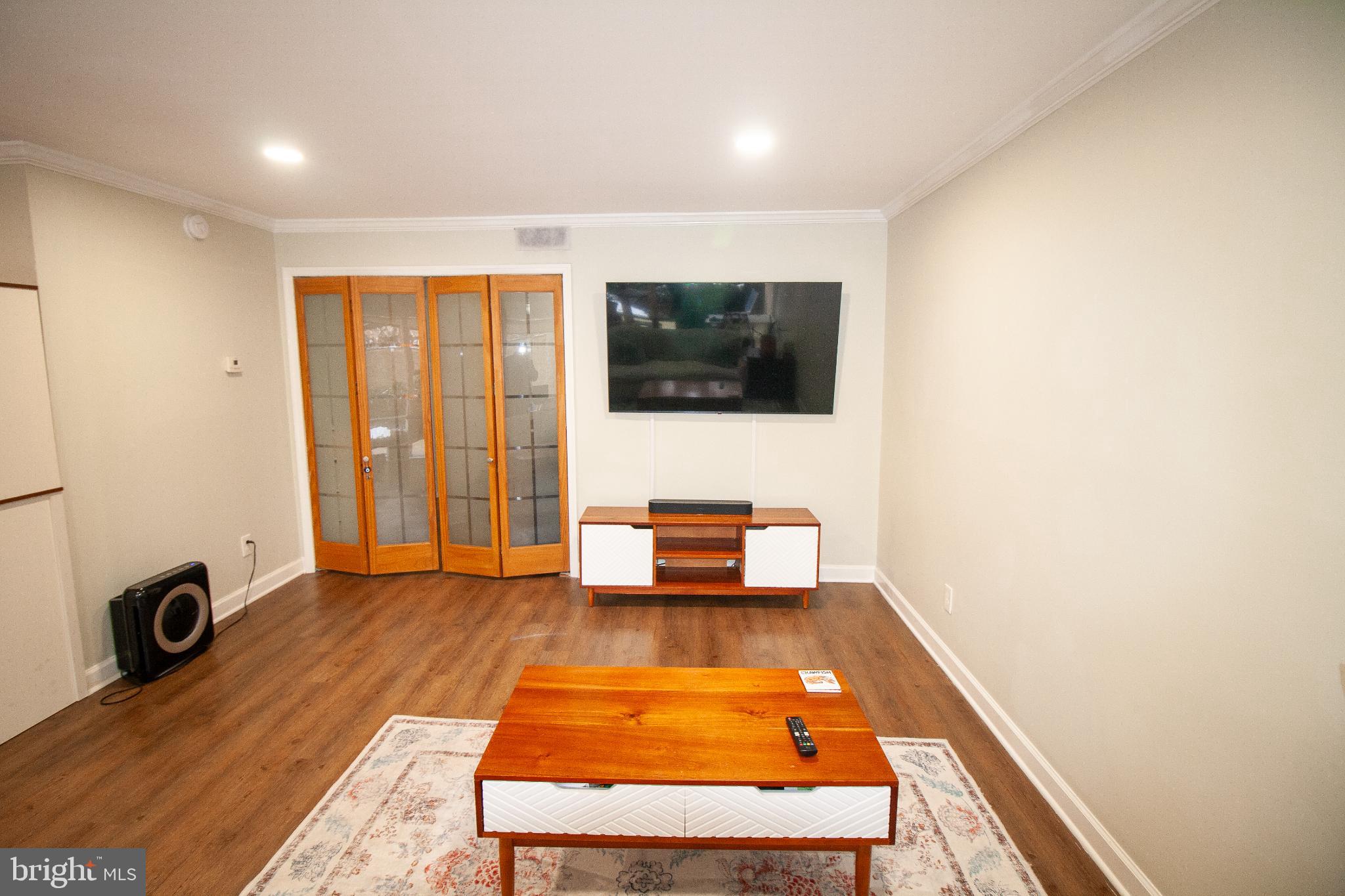 7548 Spring Lake Drive, Unit A Bethesda, MD 20817 - Photo 5 of 23 a living room with furniture and a flat screen tv