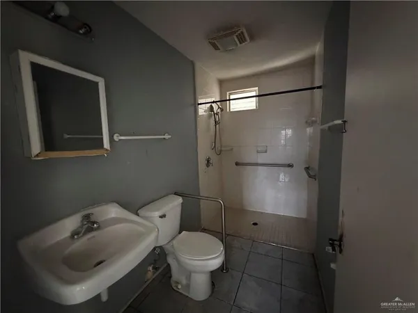 a bathroom with a toilet sink vanity and shower