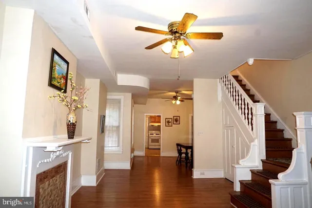 a view of a livingroom with wooden floor and a ceiling fan