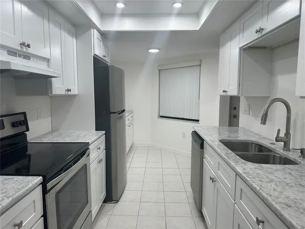 a kitchen with stainless steel appliances granite countertop a sink stove and refrigerator