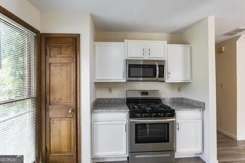 a kitchen with a sink a window and cabinets