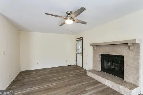 an empty room with windows and fireplace
