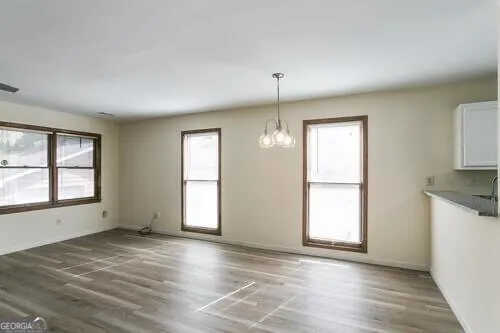 an empty room with wooden floor and a ceiling fan