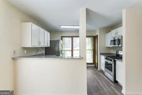a kitchen with stainless steel appliances granite countertop a refrigerator and a sink