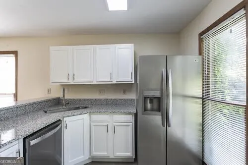 a kitchen with stainless steel appliances granite countertop white cabinets and a stove top oven