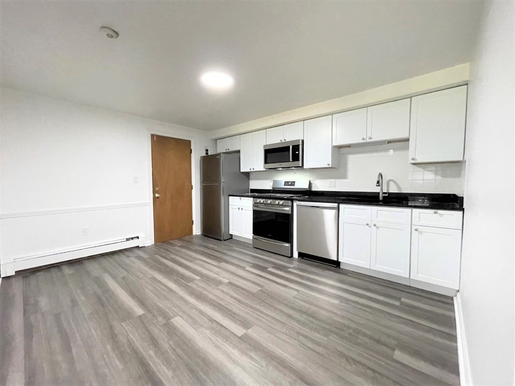 a view of kitchen with granite countertop cabinets and black stainless steel appliances