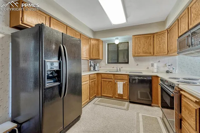 a kitchen with stainless steel appliances granite countertop a refrigerator a stove and a sink with cabinets