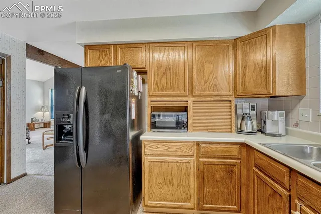 a kitchen with stainless steel appliances granite countertop a refrigerator and a sink