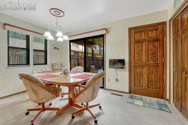 a dining room with furniture a chandelier and window