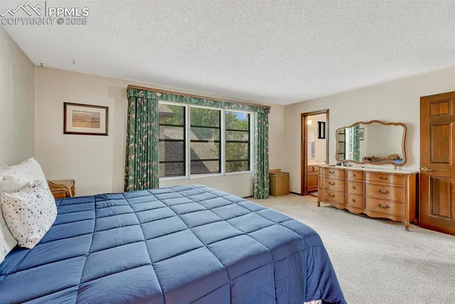 a bedroom with a large bed and wooden floor