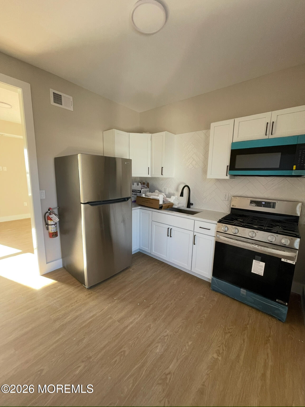 142 State Street, Unit 4 Perth Amboy, NJ 08861 - Photo 4 of 4 a kitchen with a refrigerator and a sink