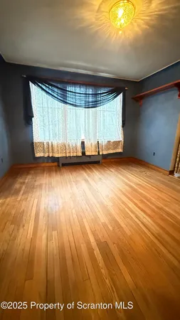 a view of a room with wooden floor and window