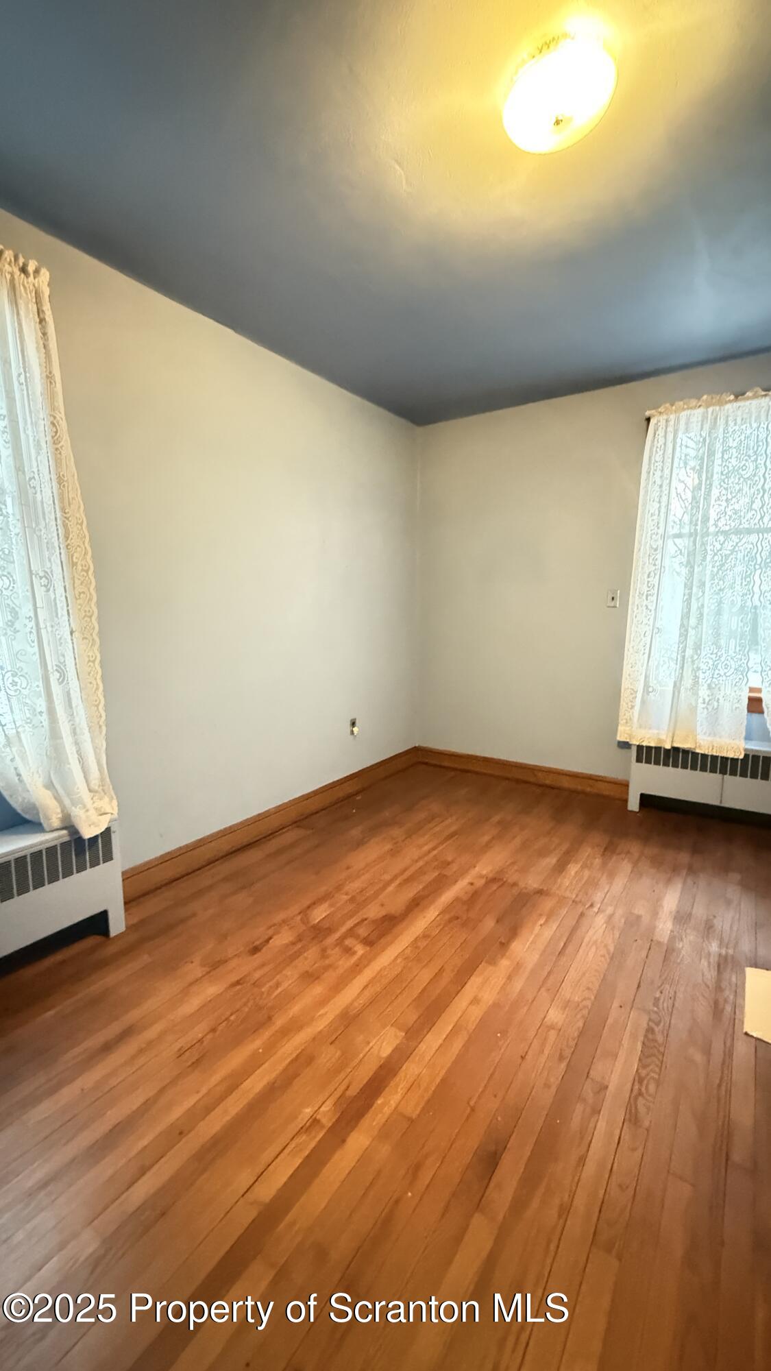 220 Hickory Ridge Road Carbondale, PA 18407 - Photo 27 of 51 an empty room with wooden floor and windows