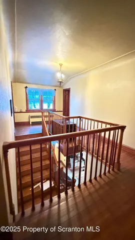 a view of a couches and dinning room with wooden floor
