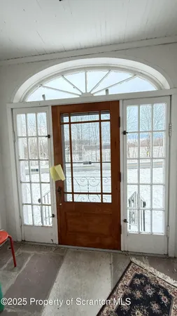 a view of an empty room with a fireplace and large windows
