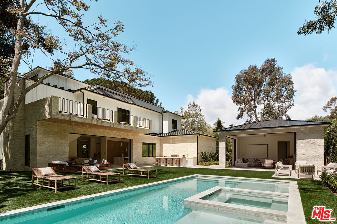 a house view with swimming pool and chairs