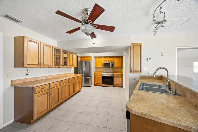 a large kitchen with stainless steel appliances granite countertop a sink and cabinets