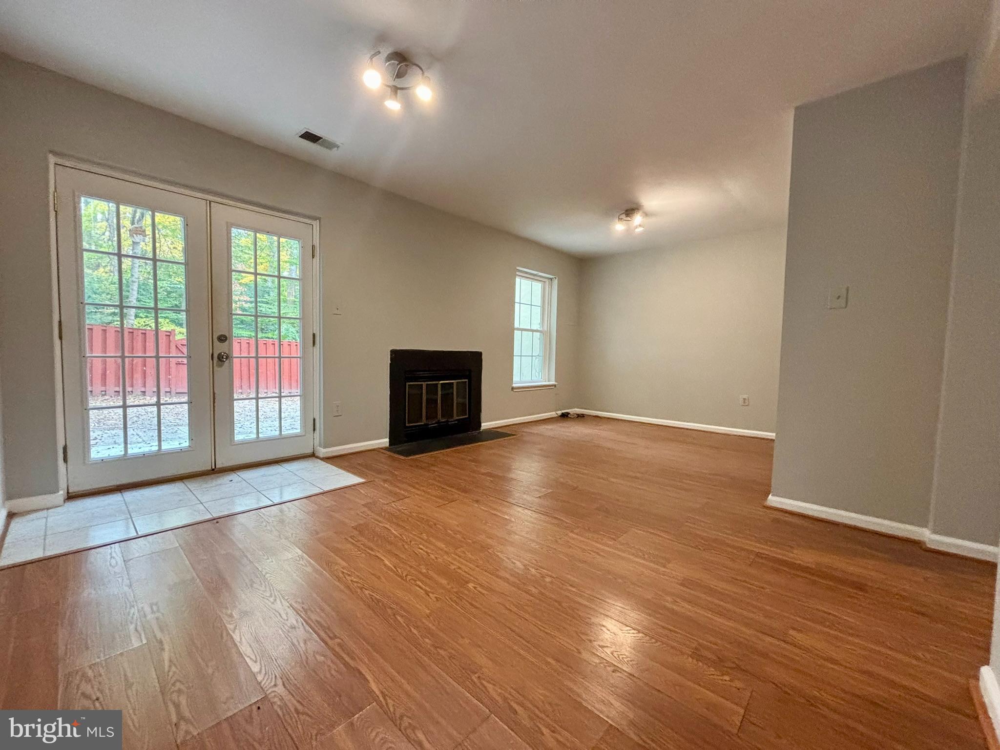 9004 Mulvaney Court Springfield, VA 22152 - Photo 20 of 23 a view of empty room with wooden floor and fireplace