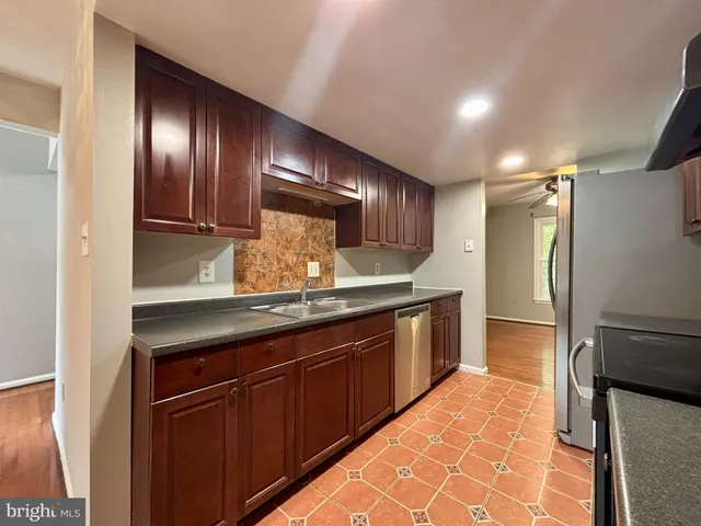 a kitchen with granite countertop stainless steel appliances and wooden cabinets
