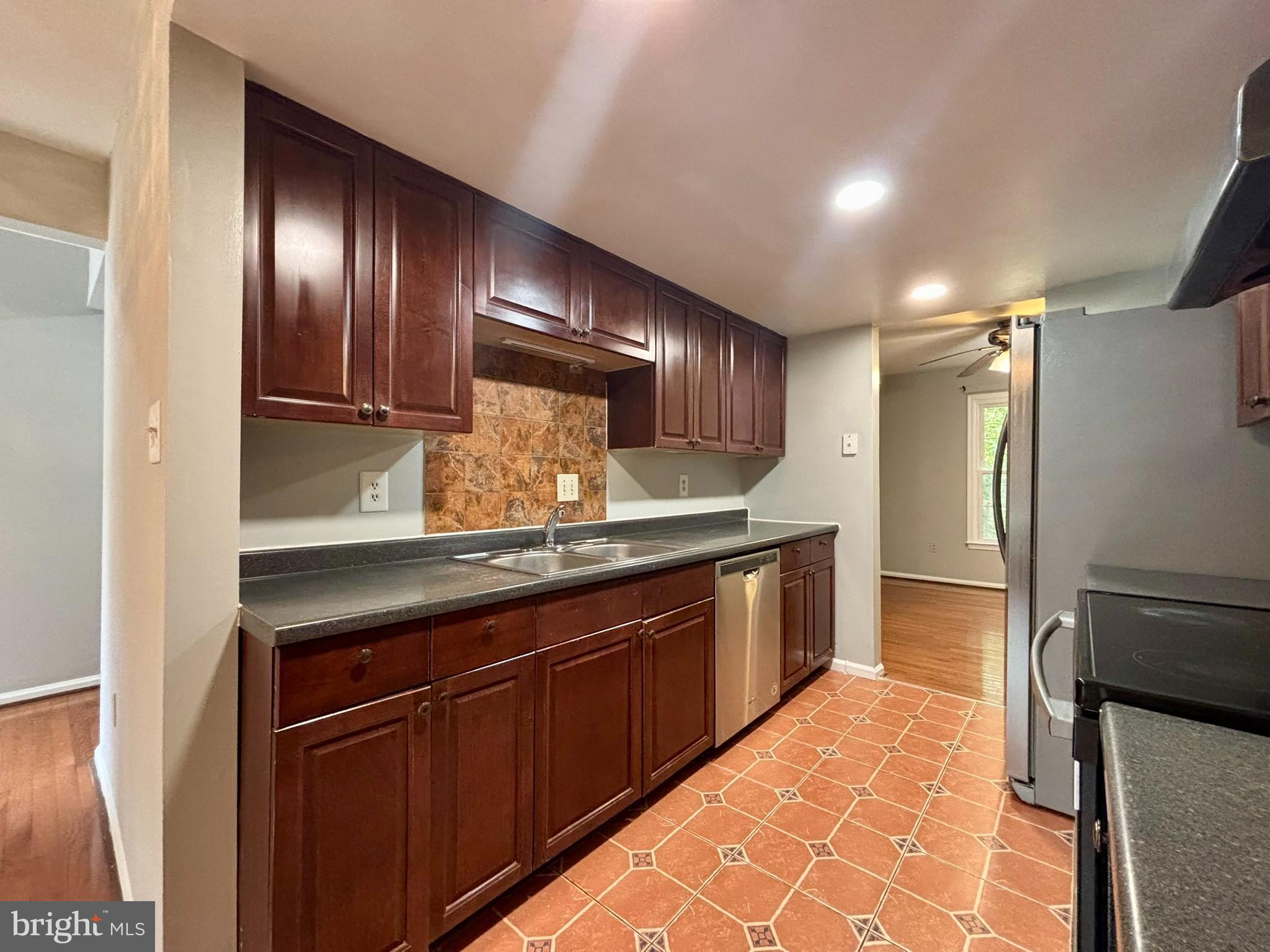 9004 Mulvaney Court Springfield, VA 22152 - Photo 5 of 23 a kitchen with granite countertop stainless steel appliances and wooden cabinets