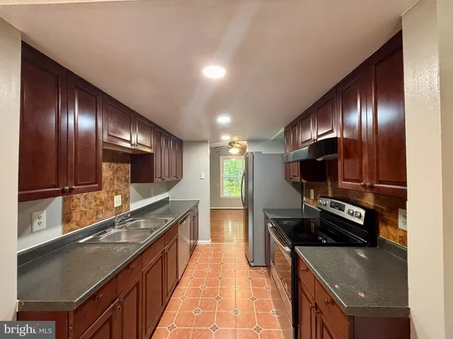 a kitchen with stainless steel appliances granite countertop a sink and a stove