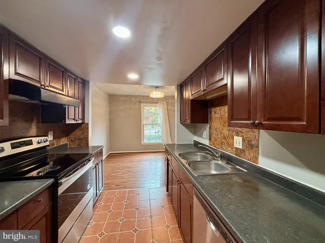 a kitchen with stainless steel appliances granite countertop a sink and a stove