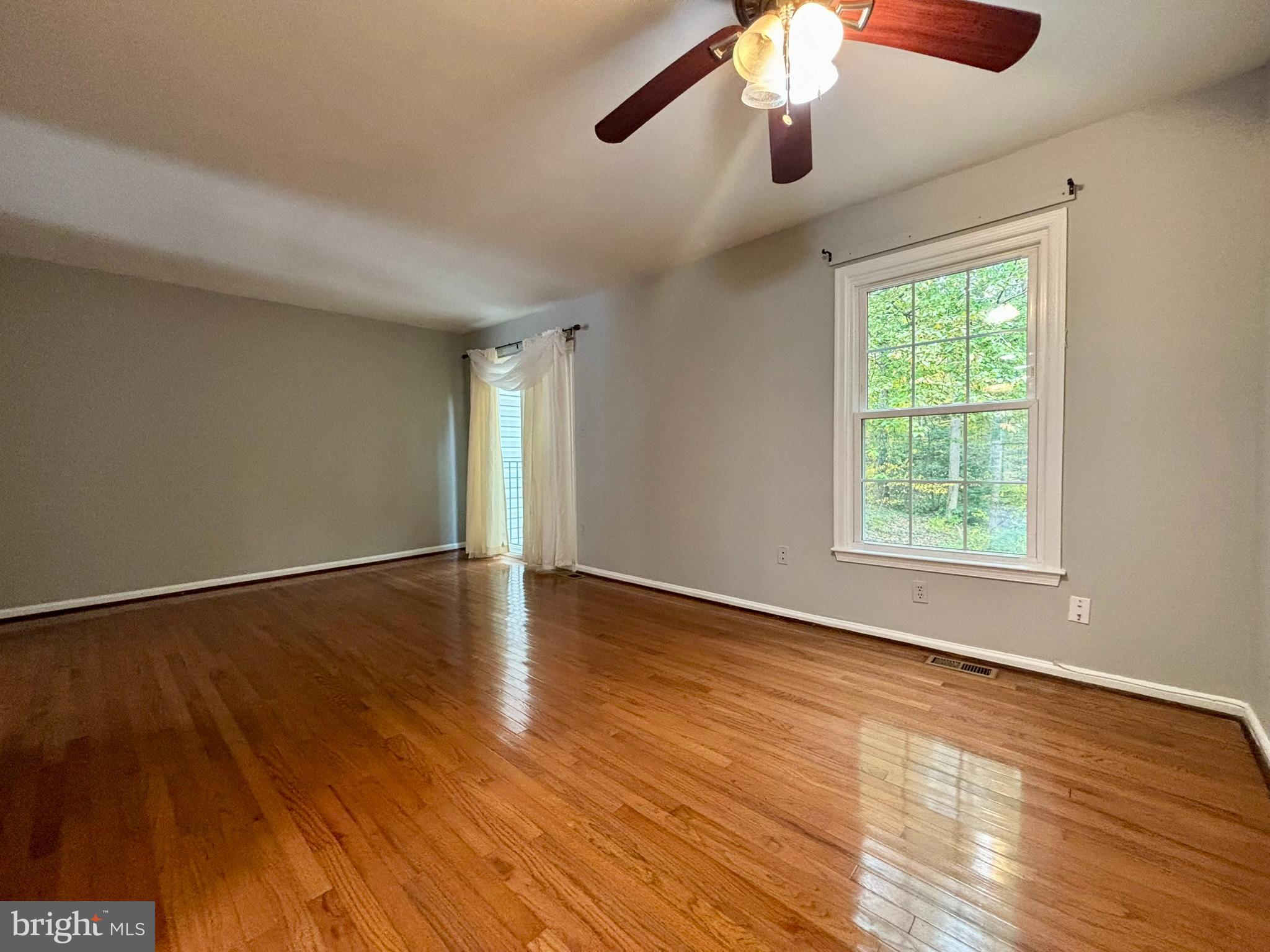 9004 Mulvaney Court Springfield, VA 22152 - Photo 10 of 23 a view of an empty room with wooden floor and a window