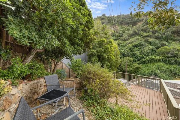 a balcony with wooden floor table and chairs