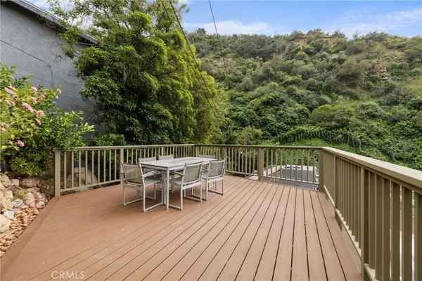 a deck with hardwood table and chairs