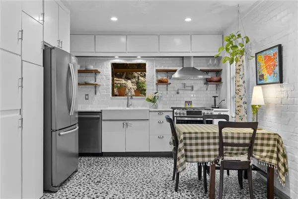 a kitchen with stainless steel appliances kitchen island granite countertop a refrigerator and a stove top oven