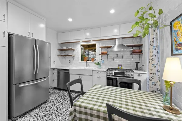 a kitchen with stainless steel appliances a stove a sink cabinets and a refrigerator