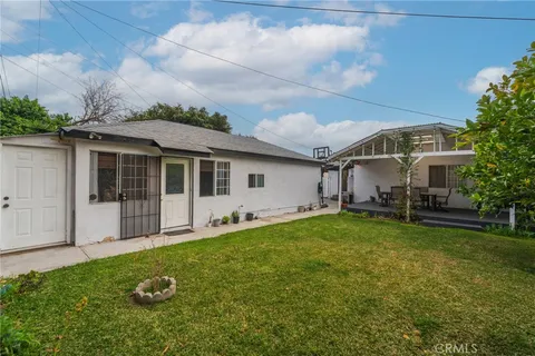 a view of a house with a yard and sitting area