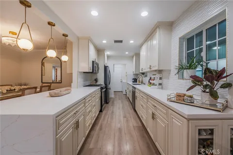 a large kitchen with kitchen island a large counter space a sink and stainless steel appliances