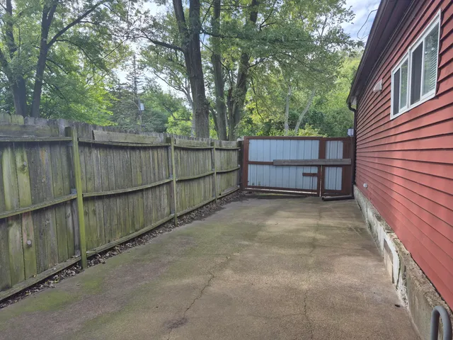 a view of backyard and wooden fence