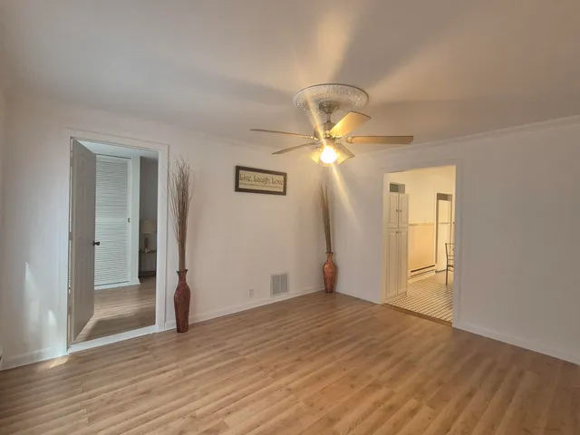 a view of empty room with wooden floor